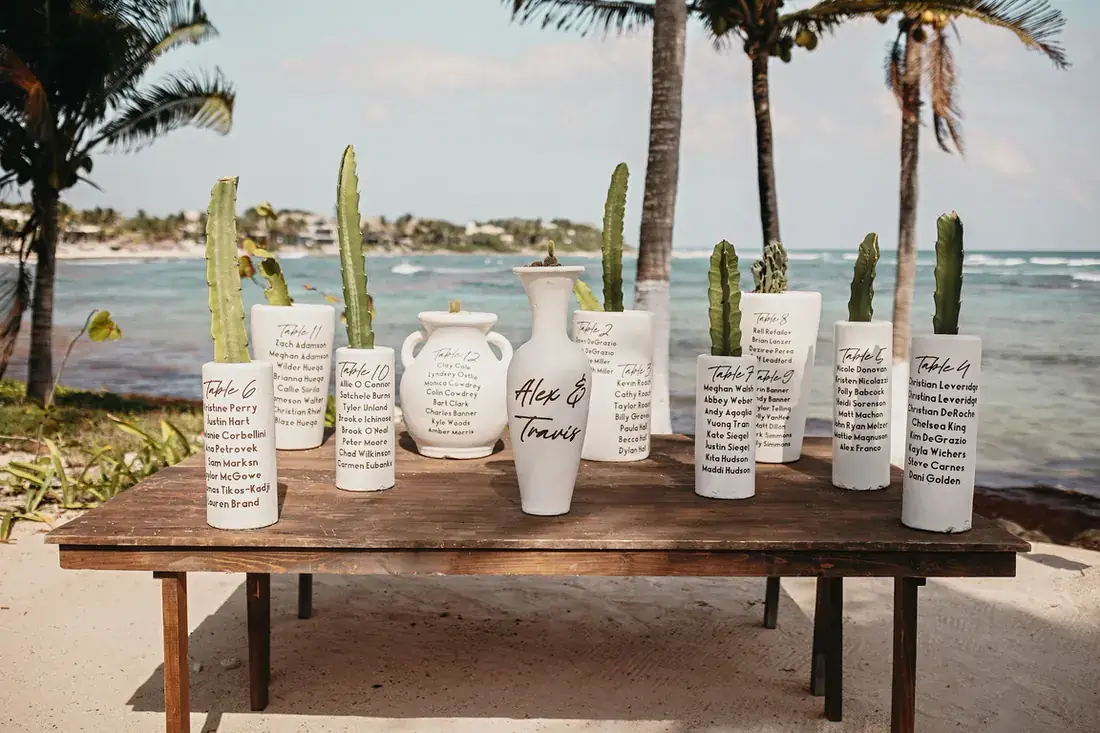 Welcome table on the beach with painted ceramic vessels and cacti