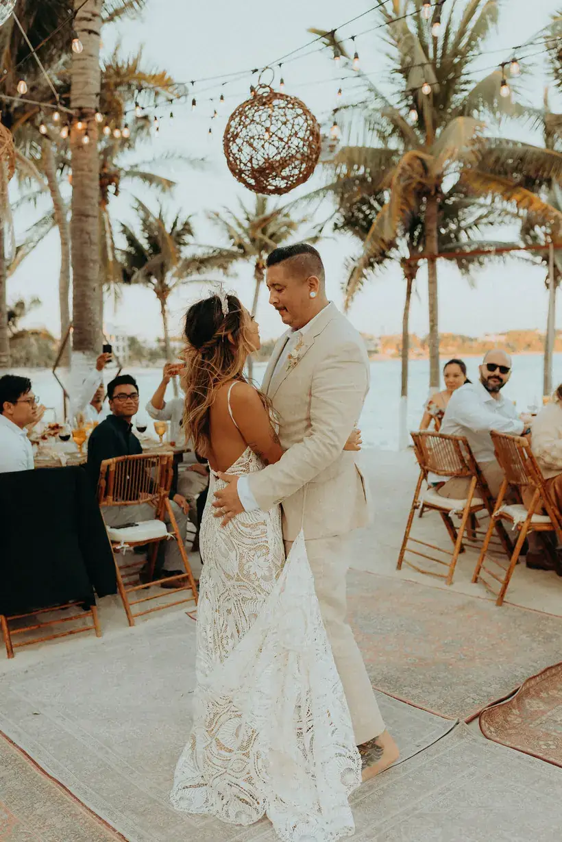 Couple dancing closely on a woven rug during the reception