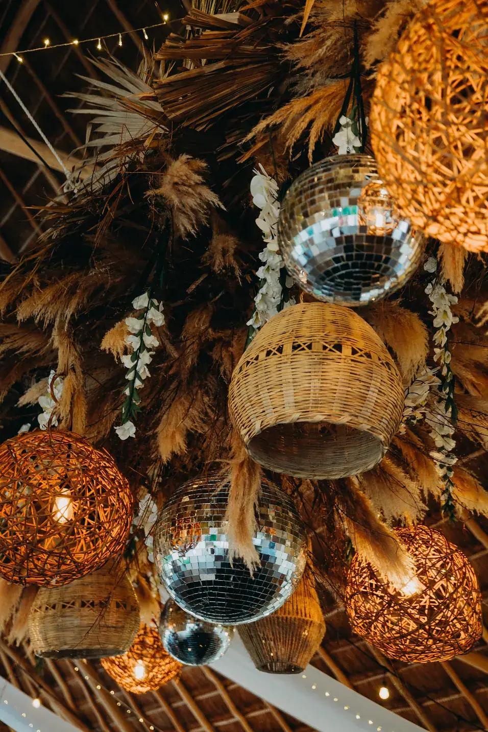 Ceiling of mirror balls, woven rattan lanterns and dried palm
