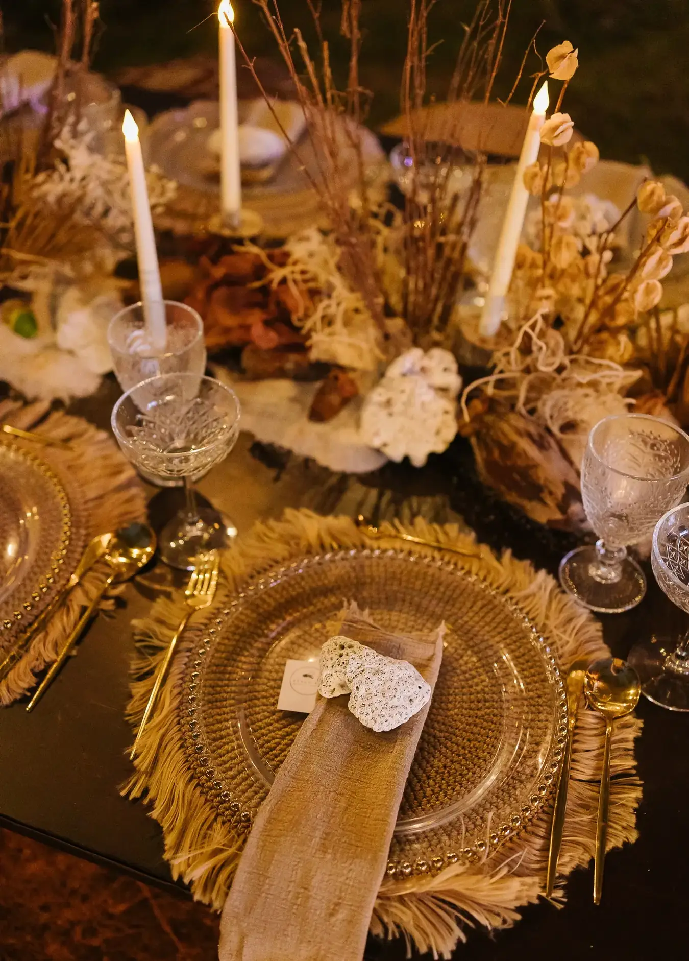 Candlelit tablescape in gold and amber with layered chargers and cut glass