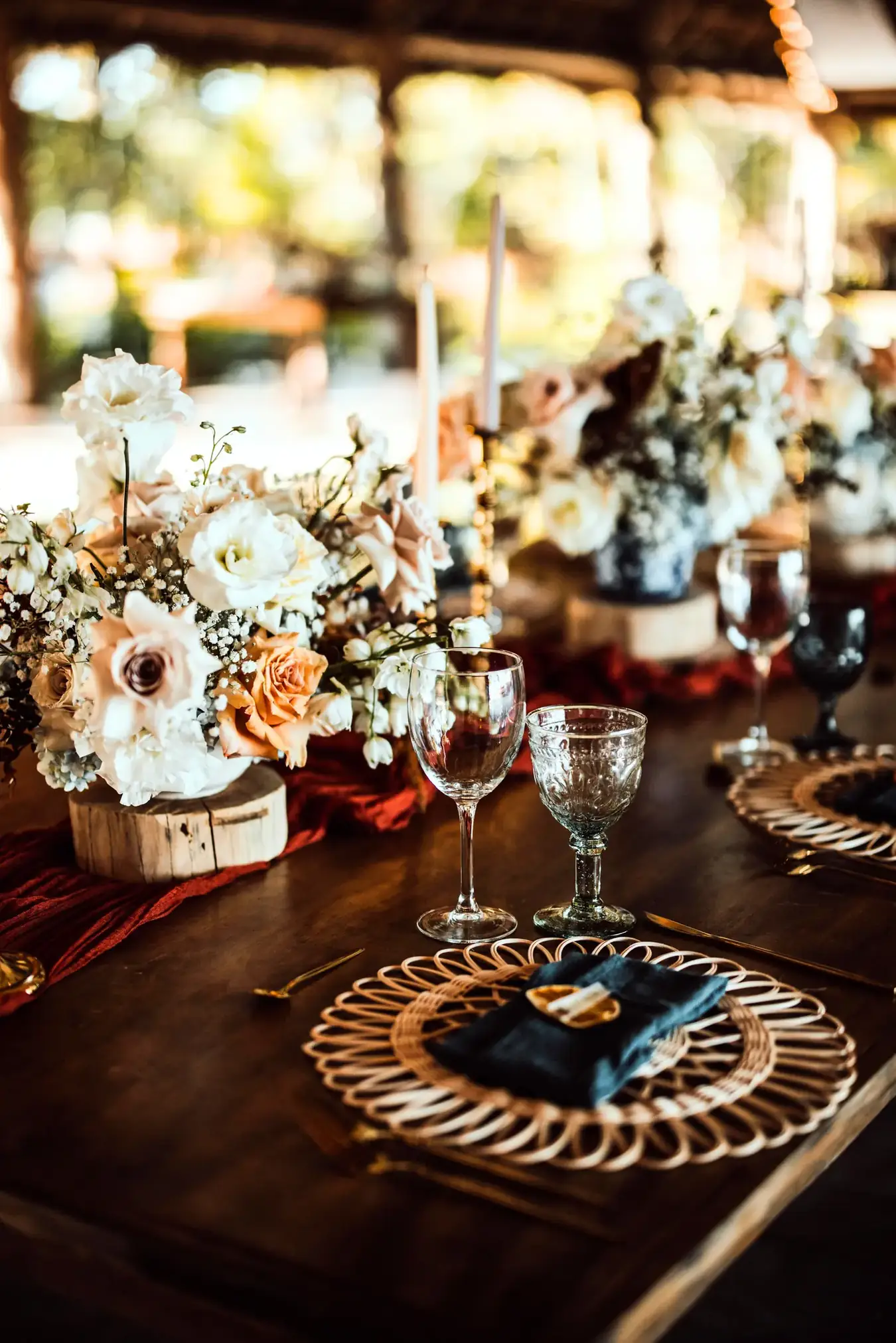 Reception place setting with gold charger, navy napkin and layered glassware