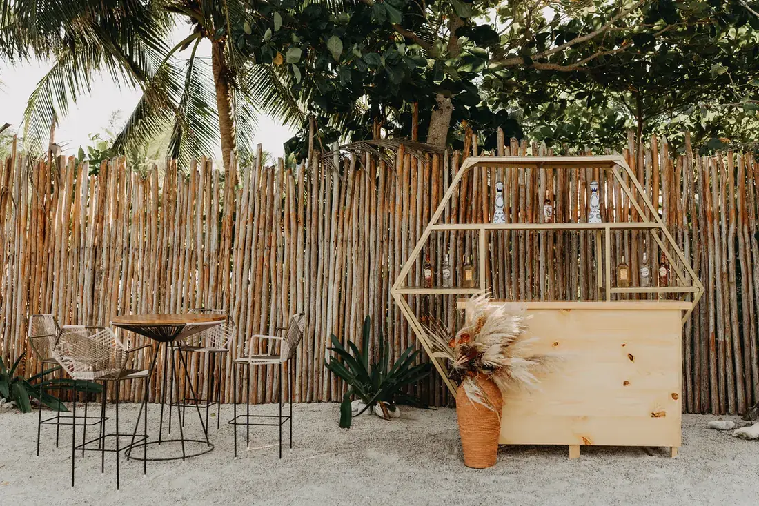 Timber hexagon bar with high tops against a bamboo screen