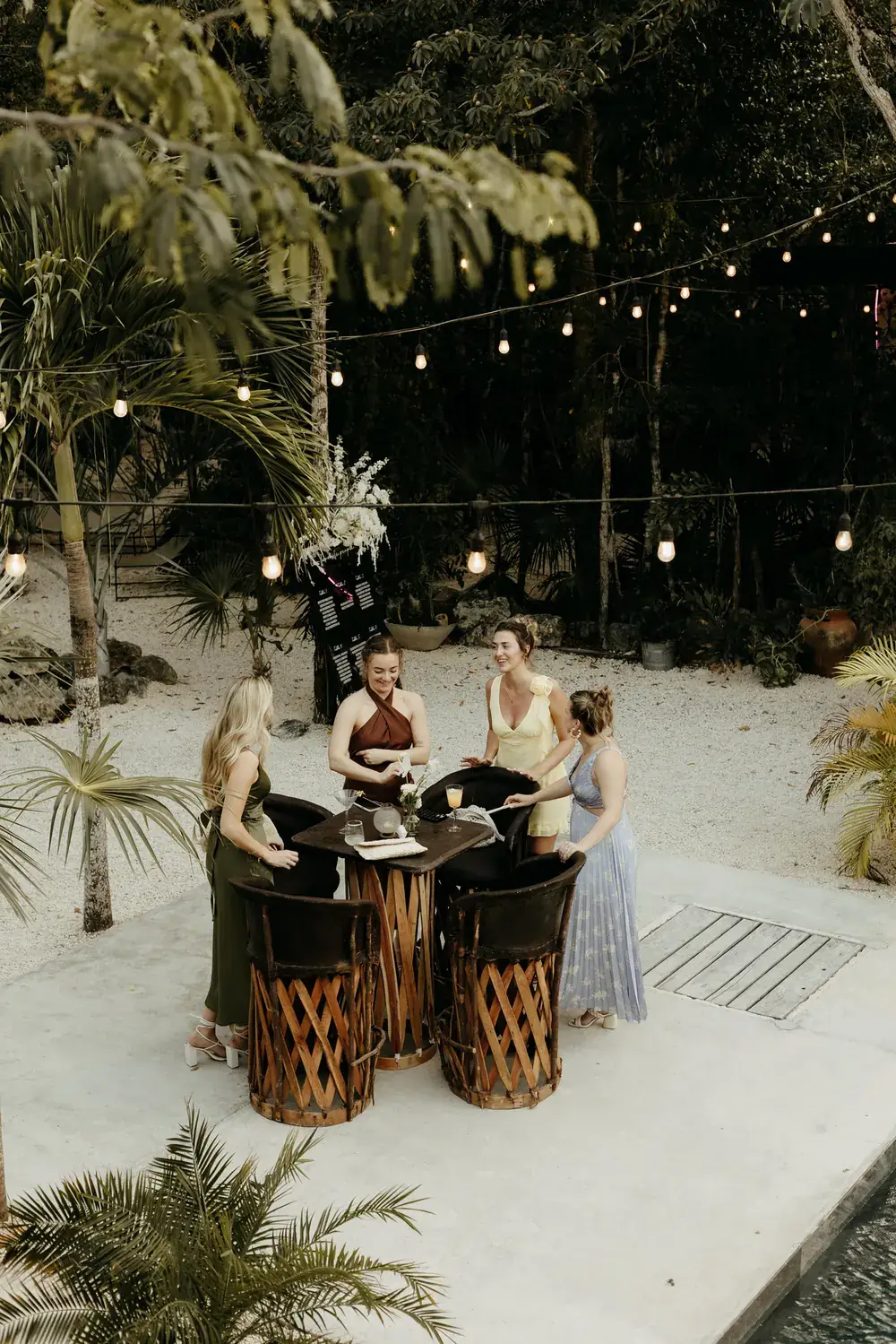 Guests gathered under string lights in a jungle clearing