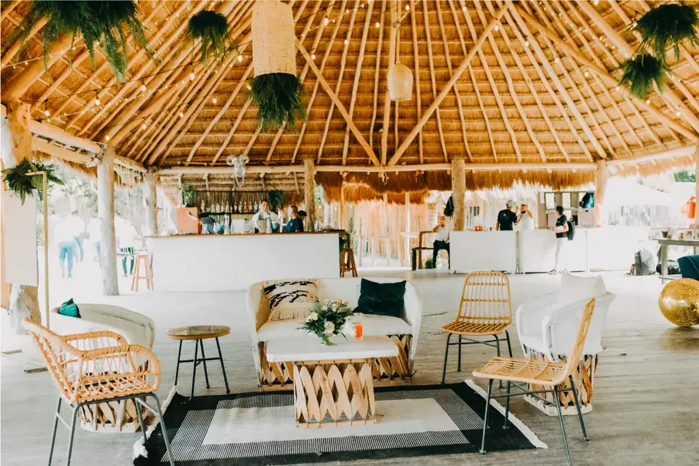Daylit palapa bar and lounge with rattan furniture and rugs