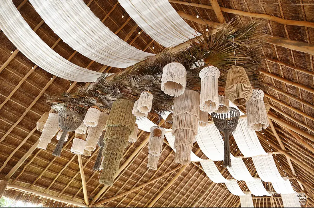 Palapa ceiling with draped fabric and clustered glass lanterns