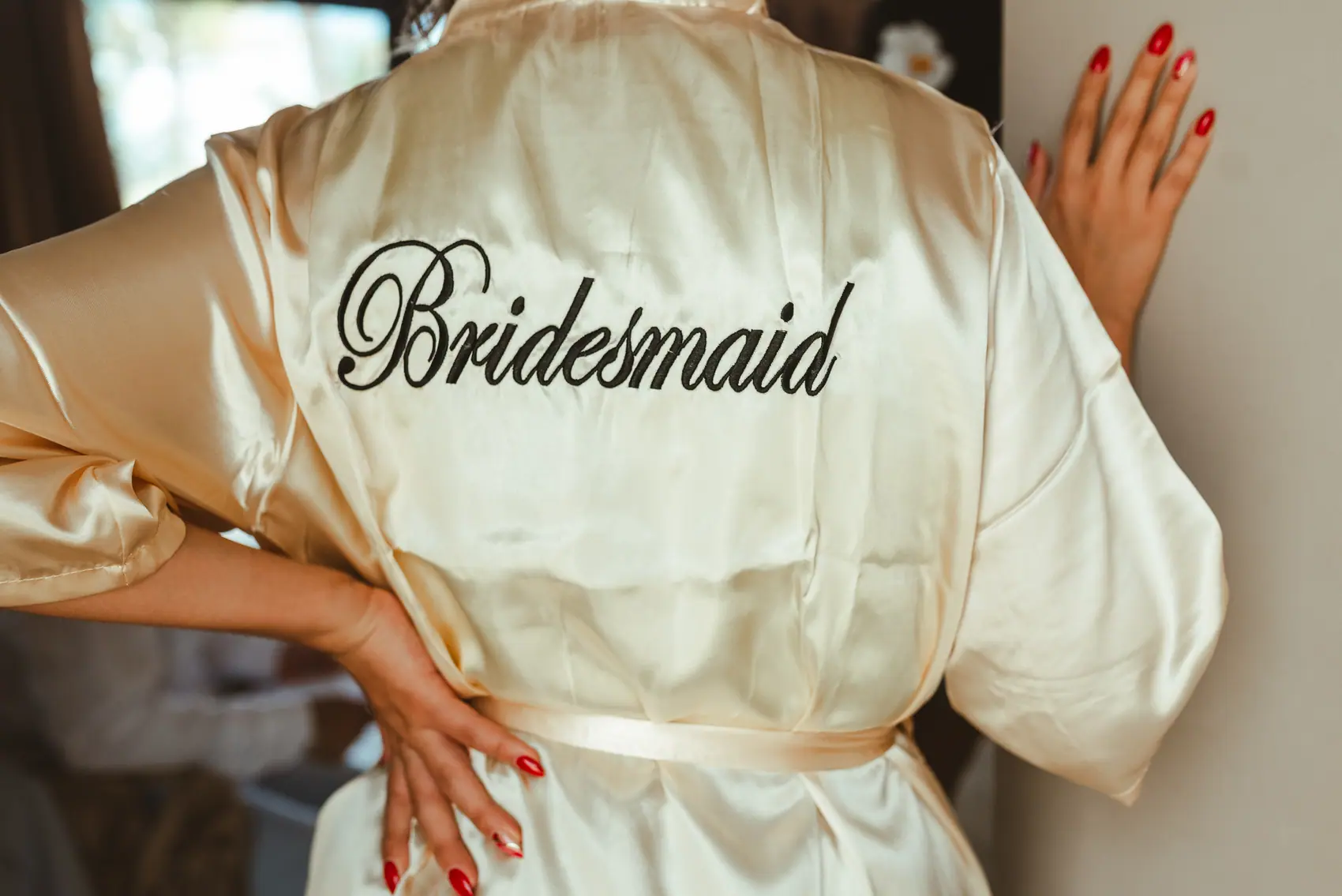 Bridesmaid in an ivory satin robe during getting-ready at a Riviera Maya wedding