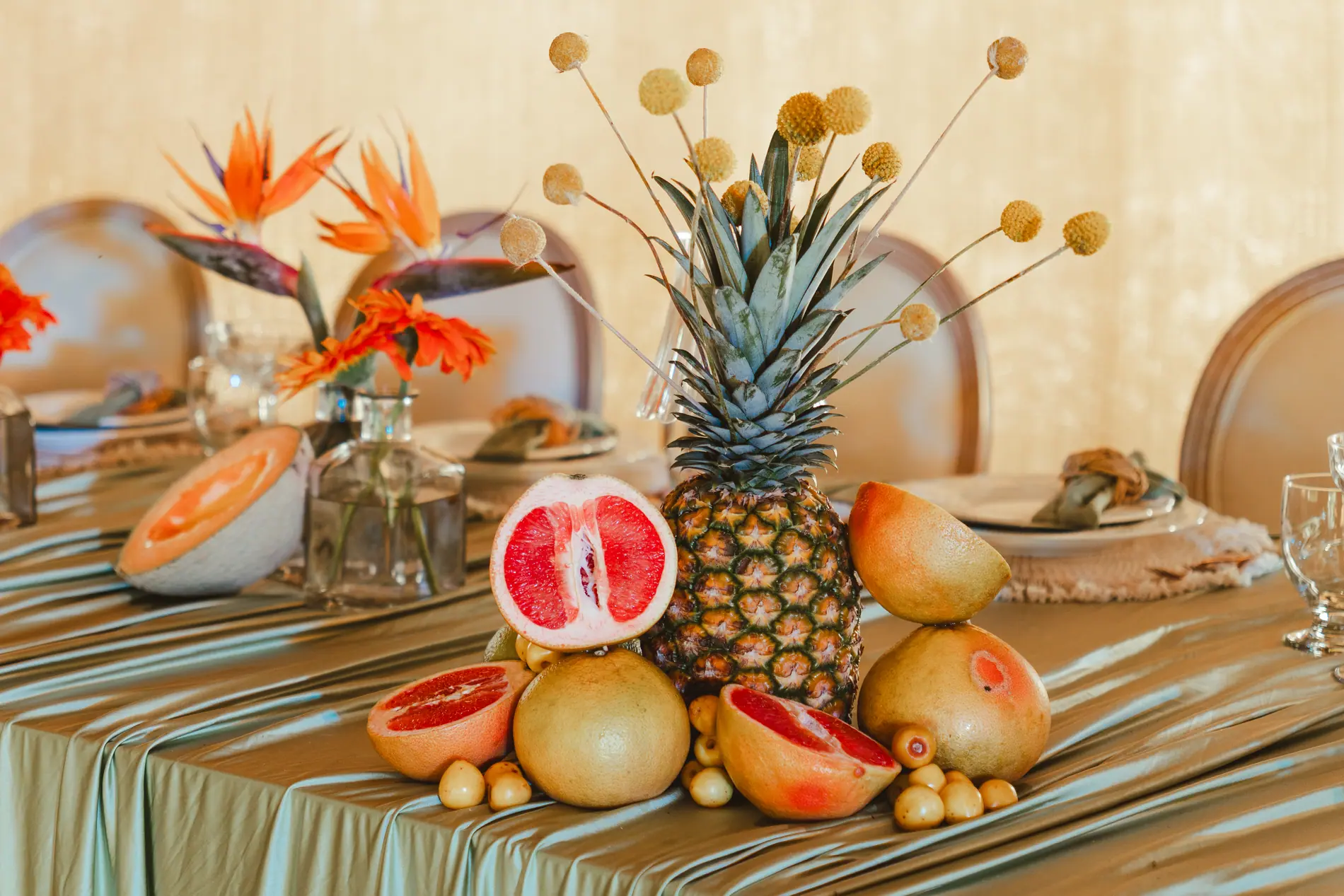 Pineapple, grapefruit and birds of paradise arranged as a tropical wedding centerpiece