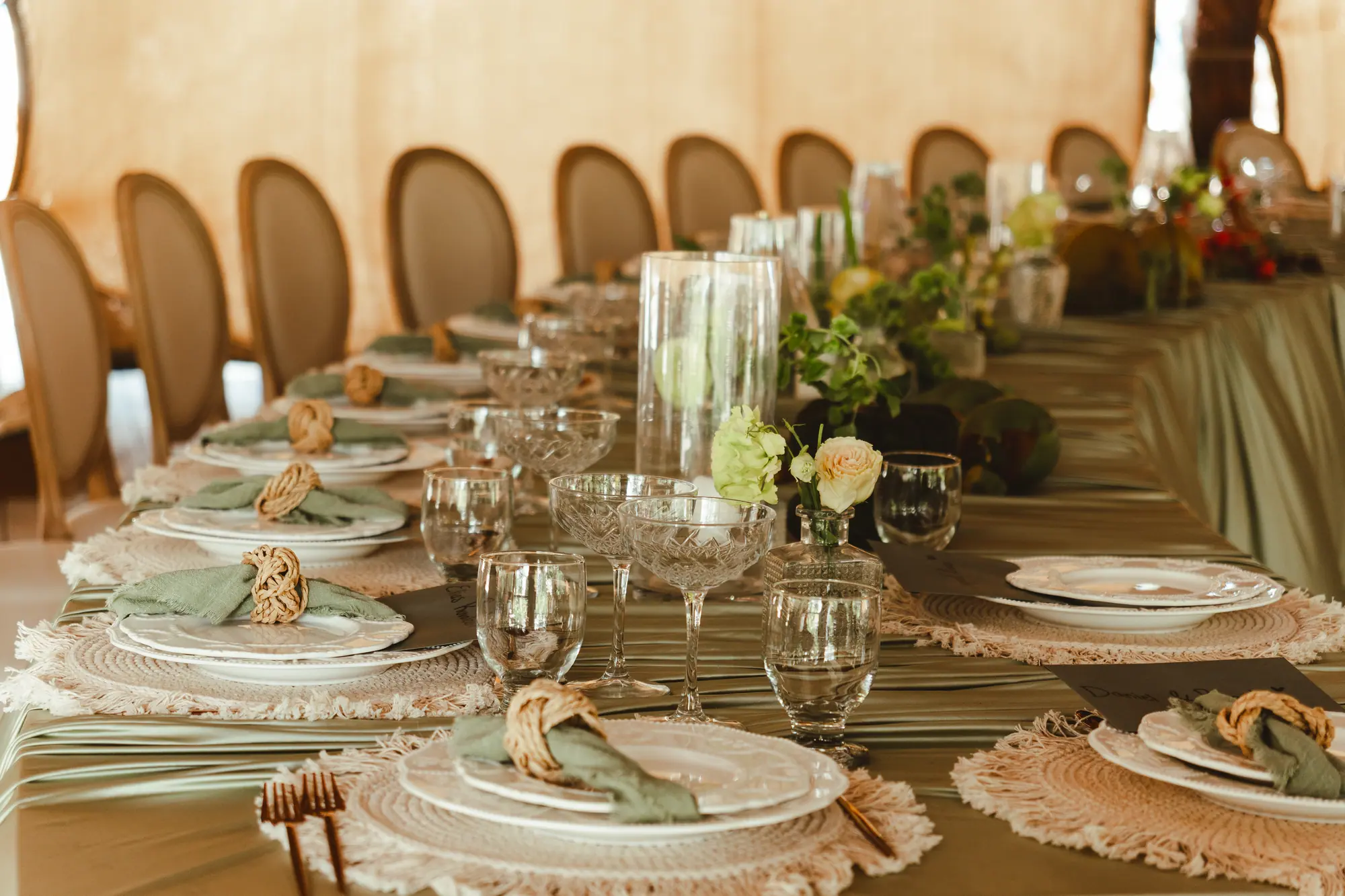 Intimate semi-circle imperial wedding table set with crochet placemats, green napkins and vintage glassware