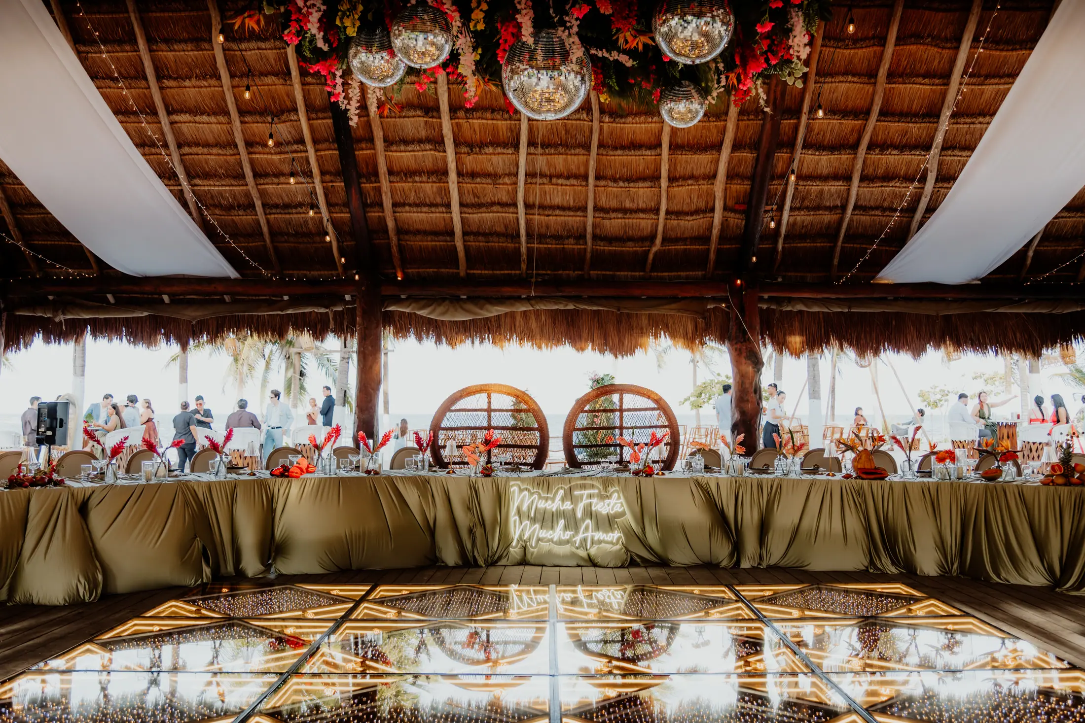 Intimate semi-circle imperial wedding table inside a Riviera Maya palapa with disco balls and a mirrored dance floor